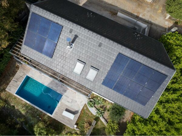 Maison avec piscine et toiture grise où est intervenu un installateur panneau solaire isere