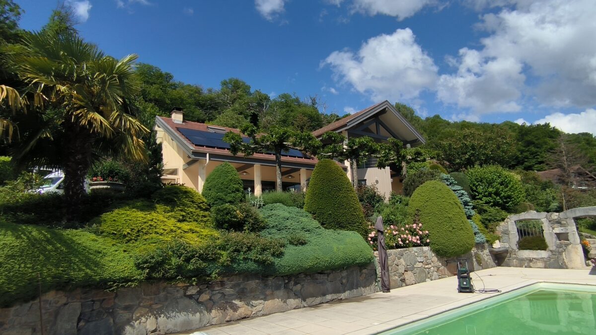 Des panneaux solaires Alpesphotons sur les toites de cette maison avec piscine