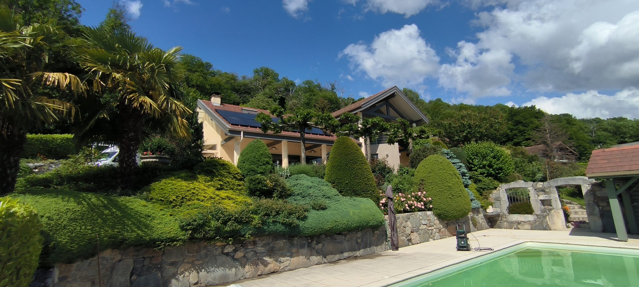 Des panneaux solaires Alpesphotons sur les toites de cette maison avec piscine