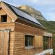 Façade bois d'un chalet de montagne devant la Dent de crolles, avec panneaux solaires Alpesphotons.